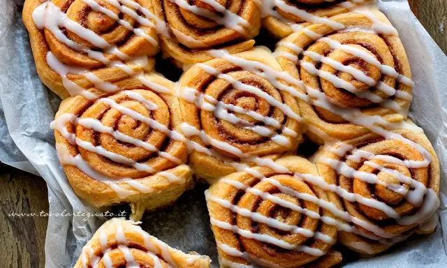 Dolci con lievito di birra, soffici girelle alla cannella con glassa bianca, pronte per essere gustate.