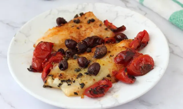 Delizioso merluzzo in friggitrice ad aria, condito con pomodorini e olive nere. Un piatto leggero e saporito.