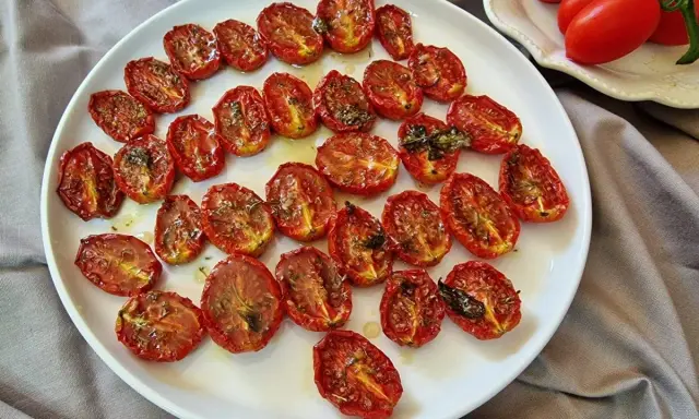 Pomodorini al forno, dorati e succosi, conditi con erbe aromatiche, pronti per insaporire ogni piatto.