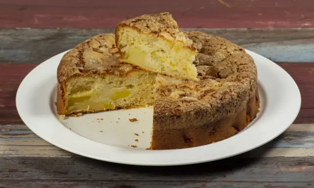Una fetta di torta di mele, soffice e dorata, con un crumble croccante. Sembra la torta di mele più buona che abbia mai mangiato.