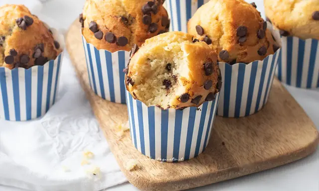 Muffin con gocce di cioccolato, perfetti per la friggitrice ad aria. Uno è stato morso, rivelando un interno soffice e goloso.