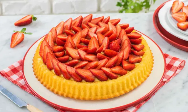 Una deliziosa crostata morbida alle fragole, ricca di frutta fresca e crema, pronta per essere gustata.