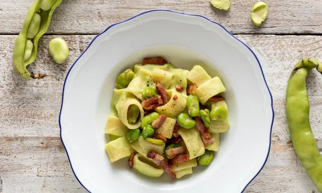 Piatto di pasta con fave fresche e croccante pancetta, un classico saporito.