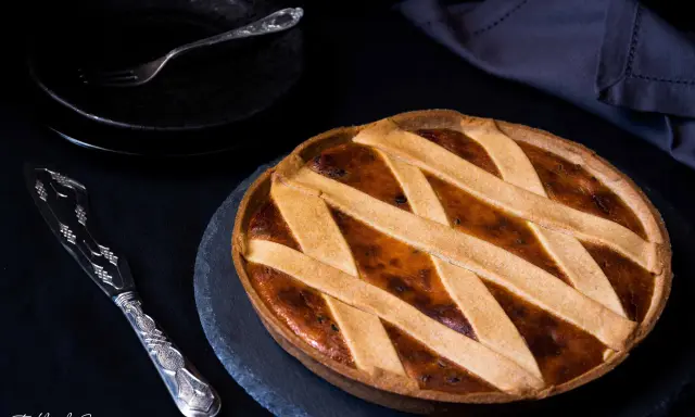 Una deliziosa crostata di ricotta, con una griglia dorata di pasta frolla, pronta per essere gustata.
