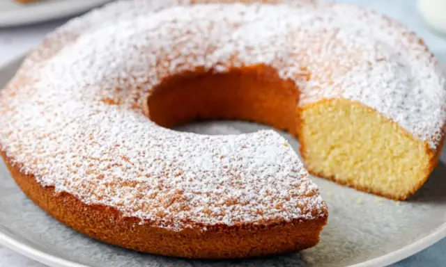 Ciambella senza glutine, soffice e dorata, cosparsa di zucchero a velo. Perfetta per una colazione o merenda golosa e leggera.