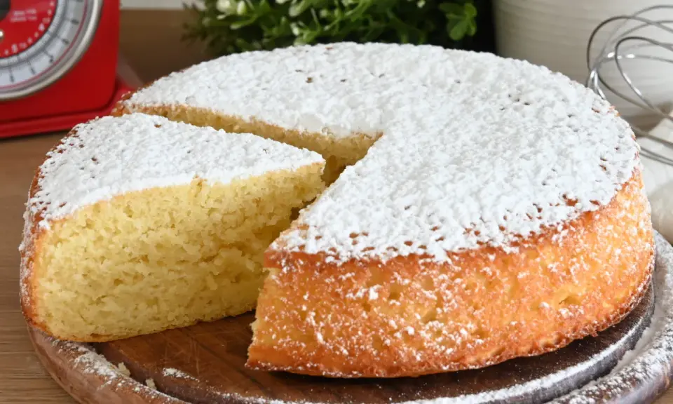 Una fetta di torta allo yogurt soffice, cosparsa di zucchero a velo, pronta per essere gustata.