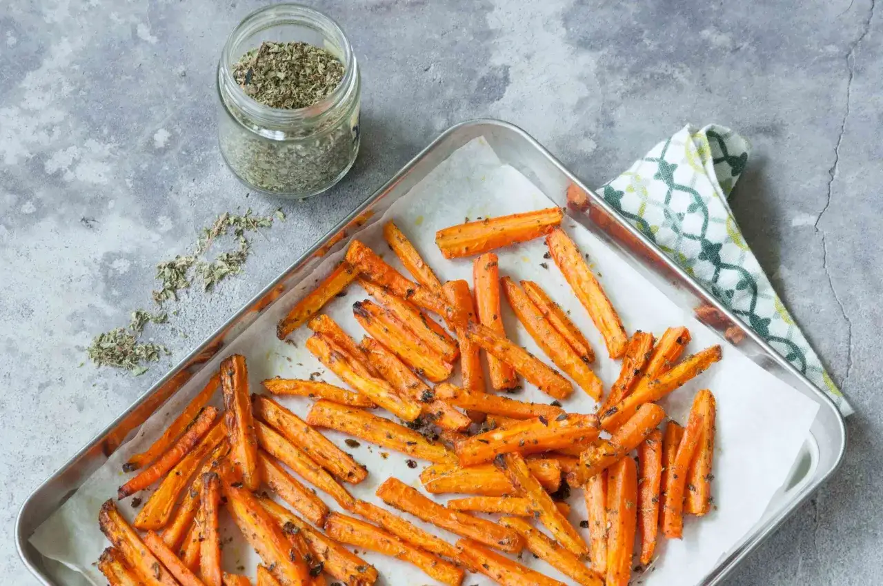 Carote al forno dorate e saporite, condite con erbe aromatiche, pronte per essere gustate.