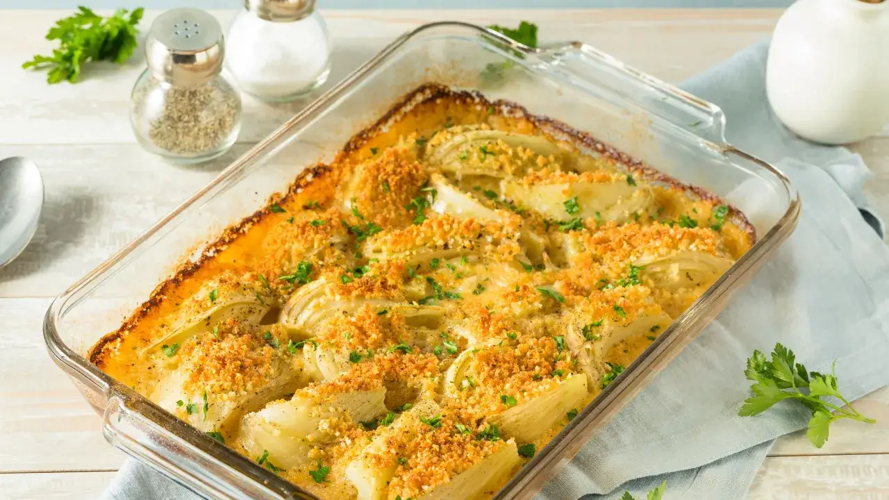 Finoçchi gratinati al forno, dorati e fragranti, con una crosticina croccante e prezzemolo fresco. Un contorno delizioso e invitante.