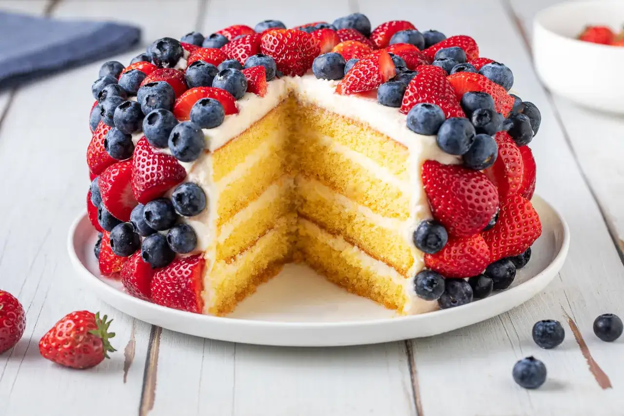 Torta mascarpone e fragole, un tripudio di colori e sapori con strati di pan di spagna, crema e frutti di bosco freschi.
