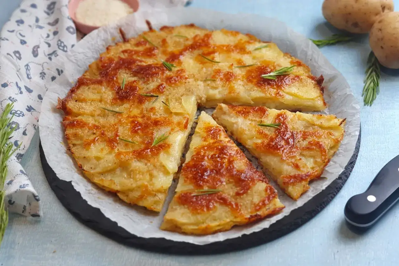 Una deliziosa torta di patate dorata e croccante, guarnita con rosmarino fresco, pronta per essere gustata.