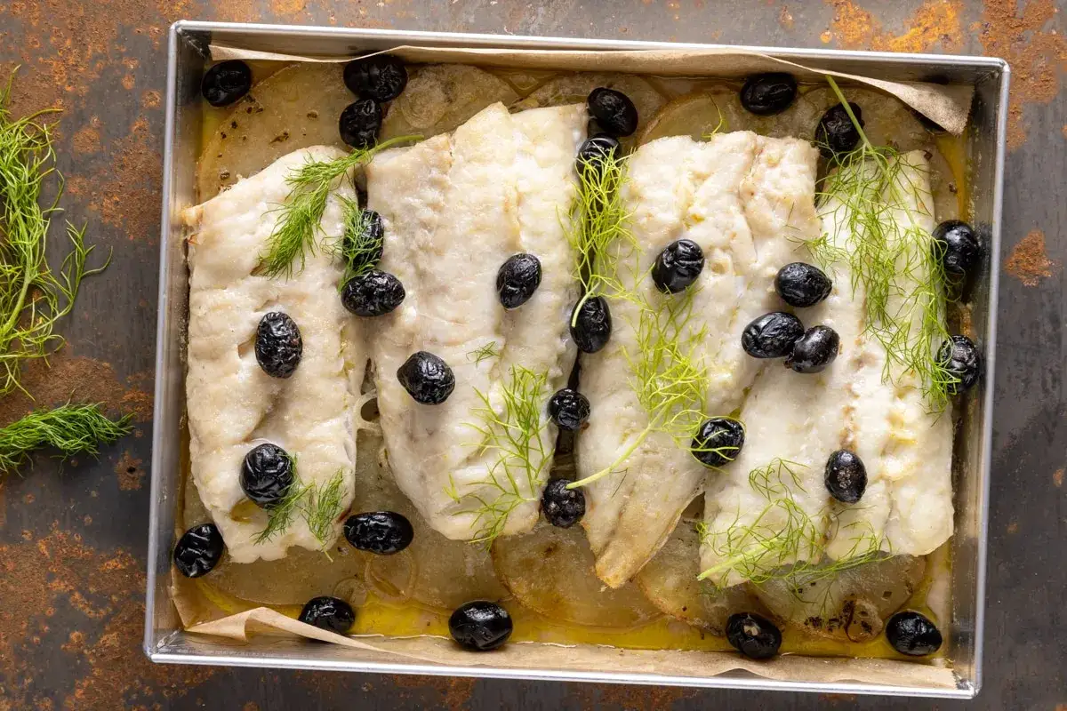 Filetti di merluzzo al forno con patate, olive nere e finocchietto fresco. Un piatto semplice e gustoso.