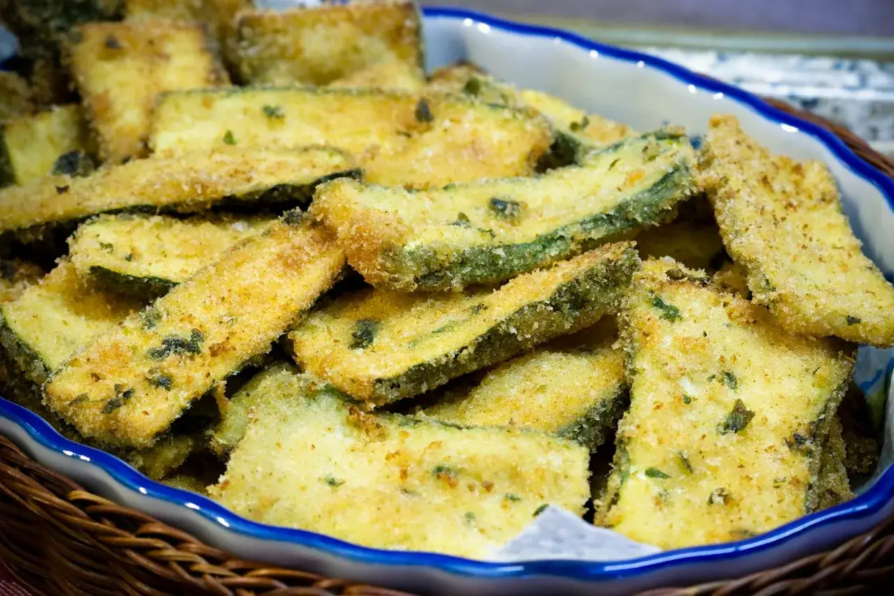Zucchine gratinate in padella, dorate e croccanti, servite in un cestino di vimini.
