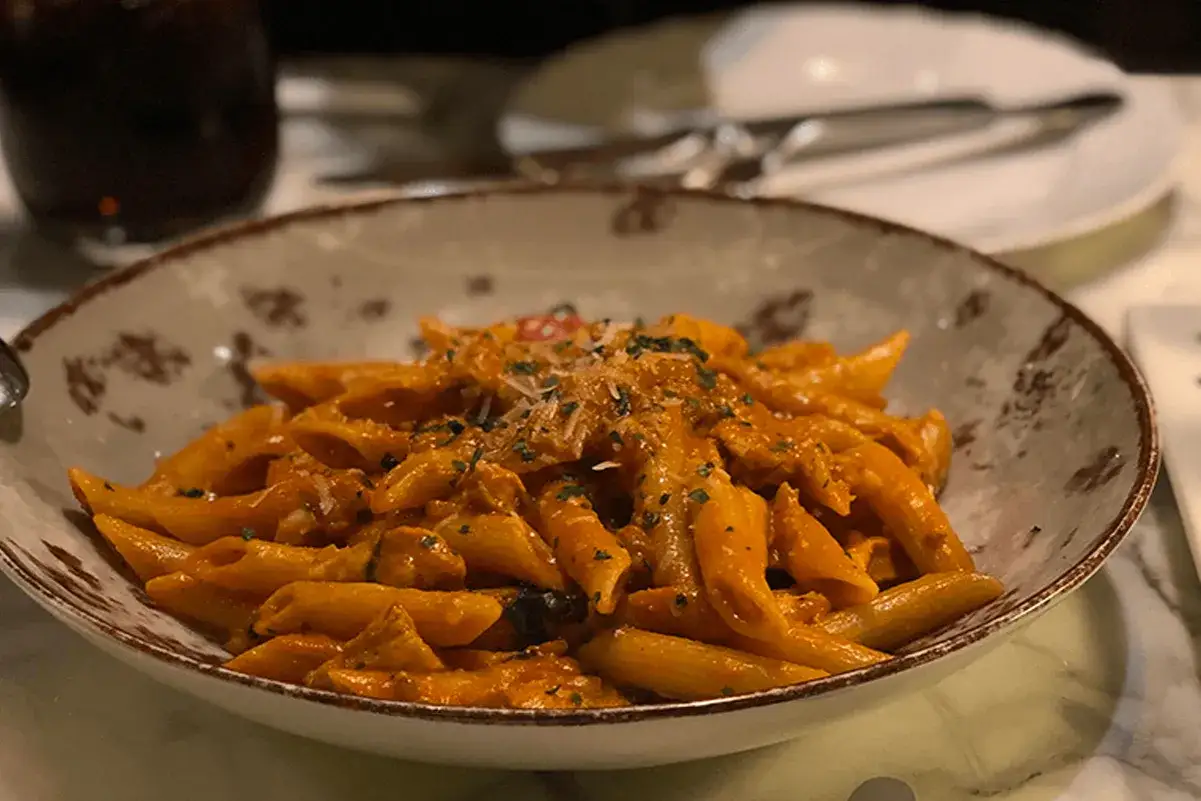 Penne al ragù di melanzane, un classico piatto di pasta e melanzane alla napoletana, servito in una ciotola rustica.