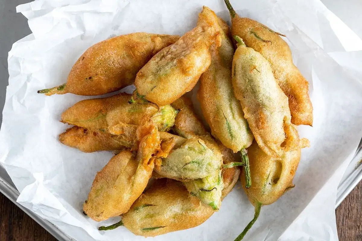 Fiori di zucca in friggitrice ad aria, dorati e croccanti, pronti per essere gustati.