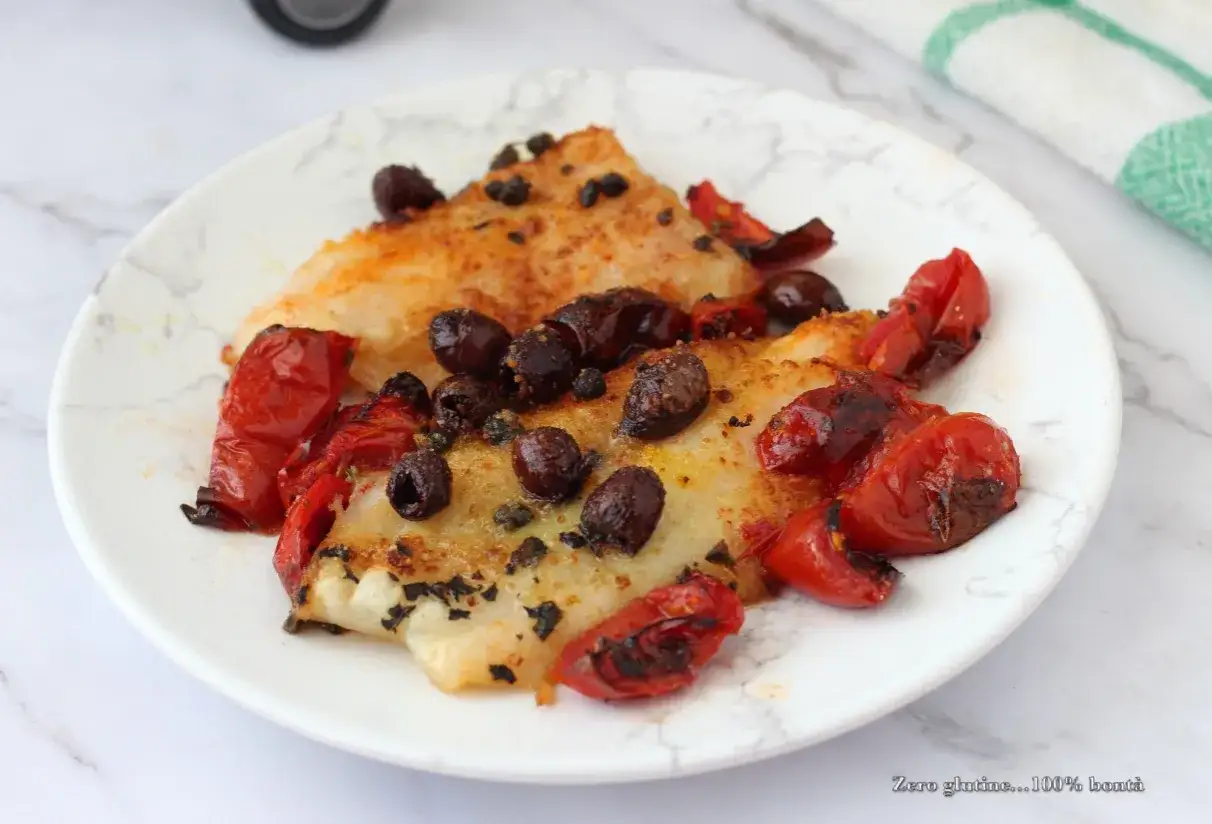 Delizioso merluzzo in friggitrice ad aria, condito con pomodorini e olive nere. Un piatto leggero e saporito.