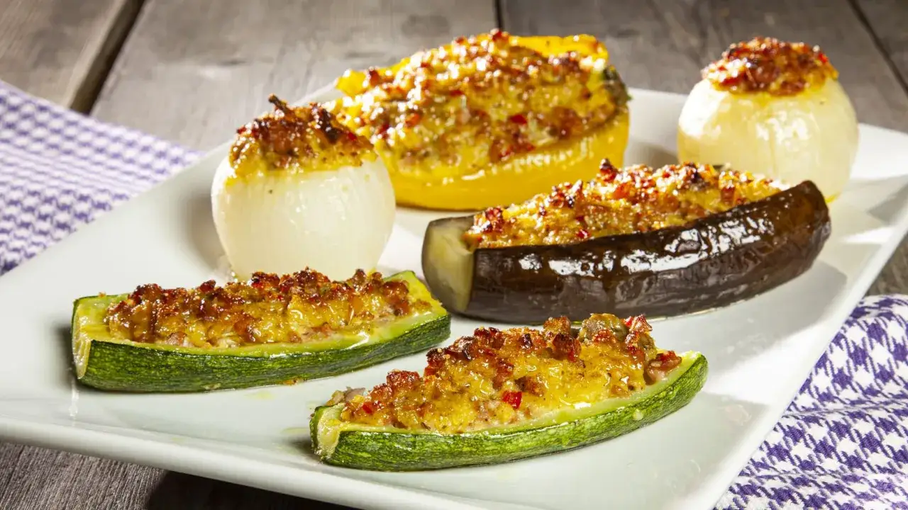 Verdure ripiene al forno: zucchine, melanzane, peperone giallo e cipolle, farcite e dorate.