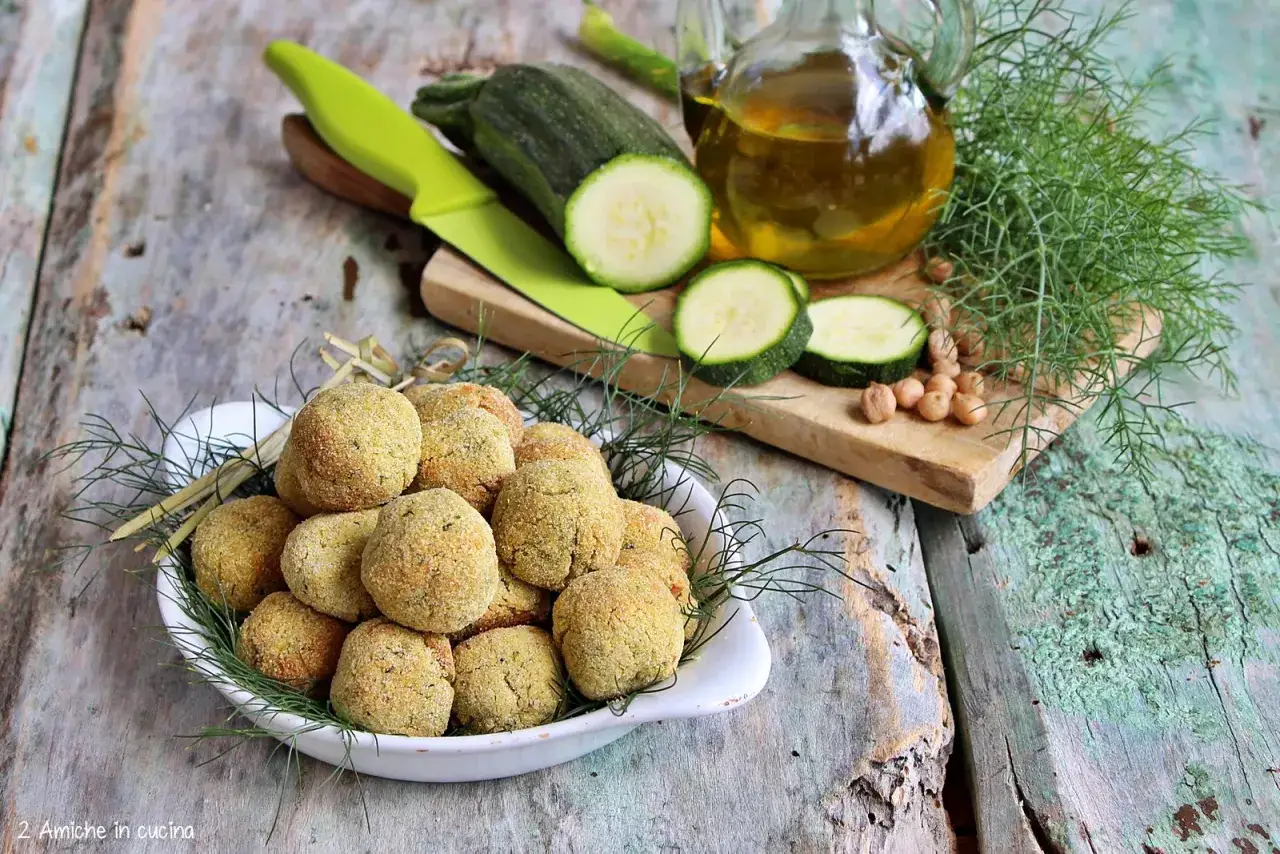 Polpette di ceci e zucchine dorate, pronte per essere gustate. Ingredienti freschi e un tocco di finocchietto selvatico.