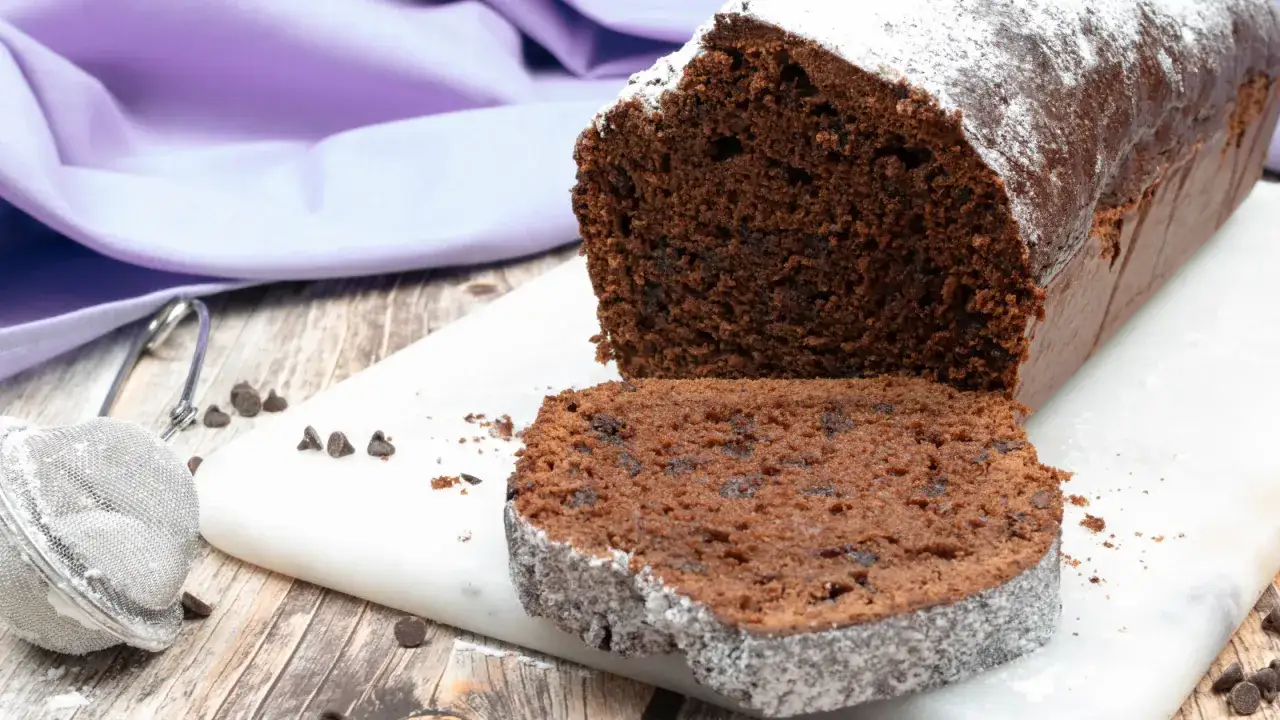 Plumcake al cioccolato con tante gocce di cioccolato, spolverato di zucchero a velo, pronto per essere gustato.