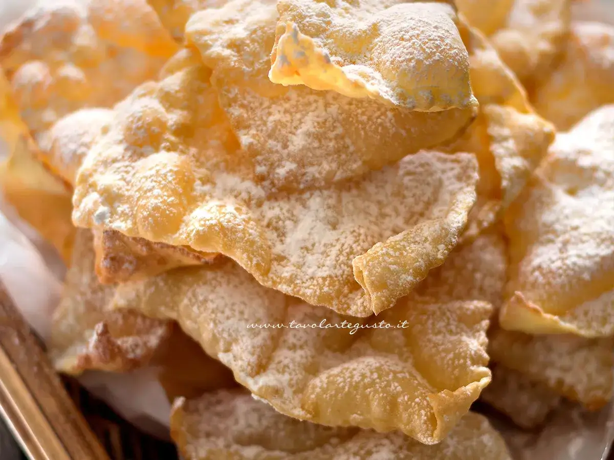 Chiacchiere croccanti, la ricetta della nonna, cosparse di zucchero a velo. Un dolce che sa di casa e tradizione.