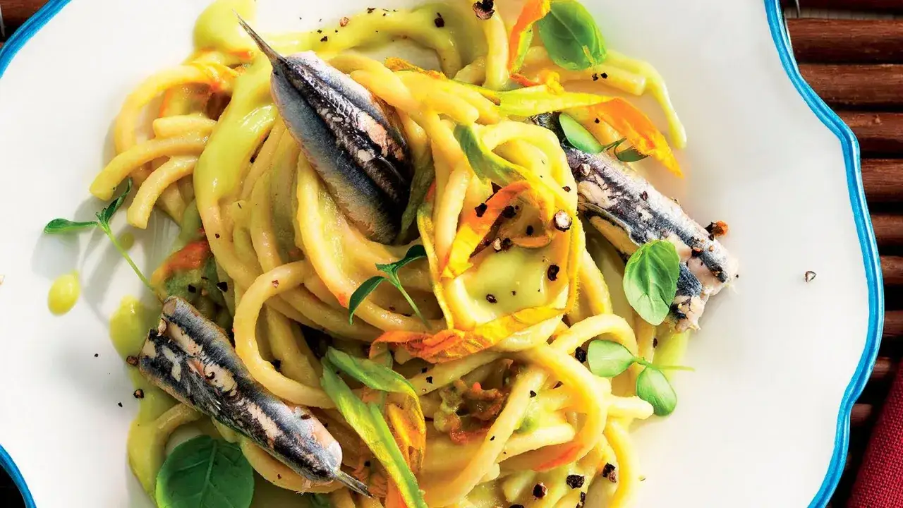 Pasta con fiori di zucca e alici, un piatto estivo profumato e saporito, con un tocco di freschezza dato dalle erbe aromatiche.