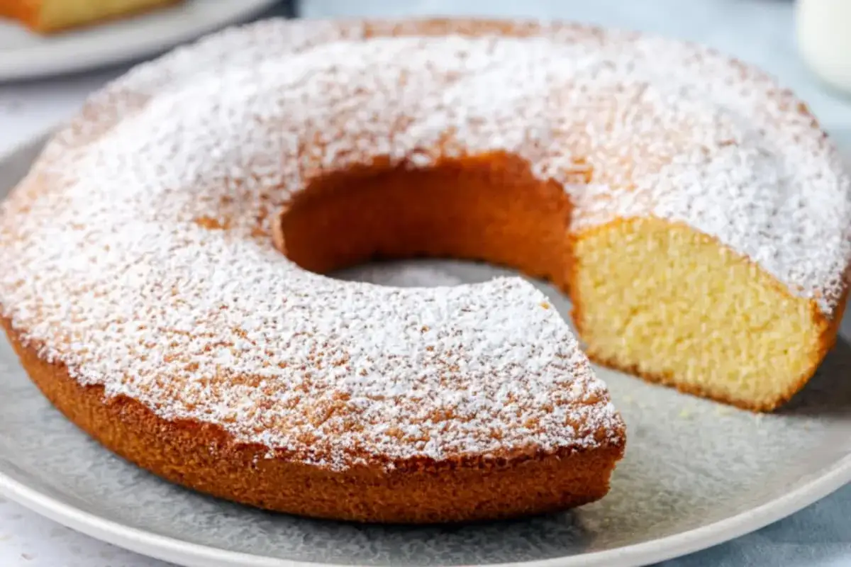 Ciambella senza glutine soffice e dorata, cosparsa di zucchero a velo. Perfetta per una colazione o merenda golosa e leggera.