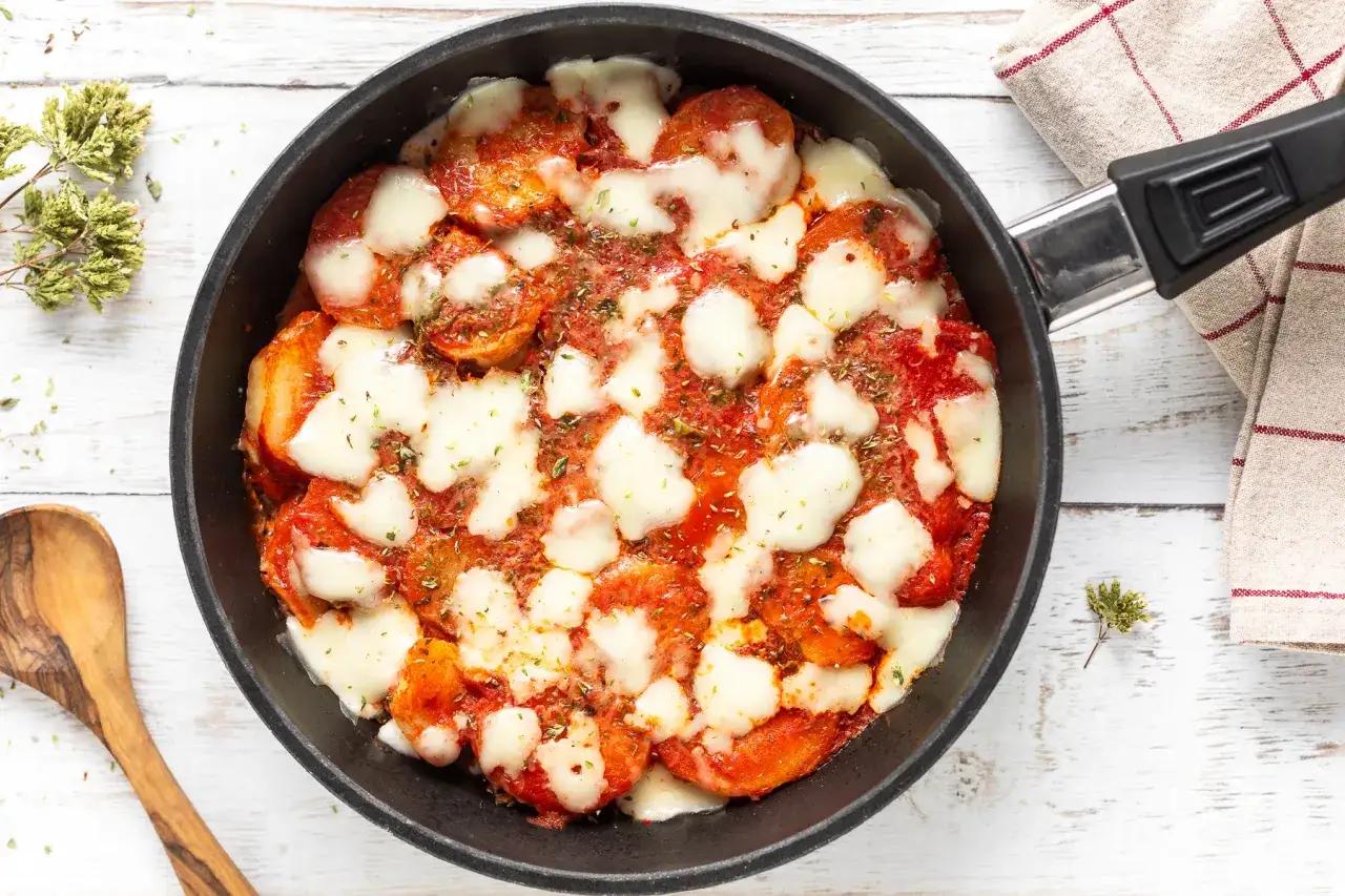 Patate alla pizzaiola in padella, con pomodoro, mozzarella filante e origano. Un piatto gustoso e facile da preparare.