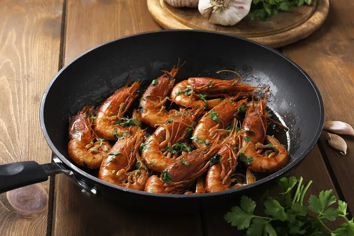 Gamberoni in padella, dorati e profumati, pronti per essere gustati. Un piatto semplice e delizioso.