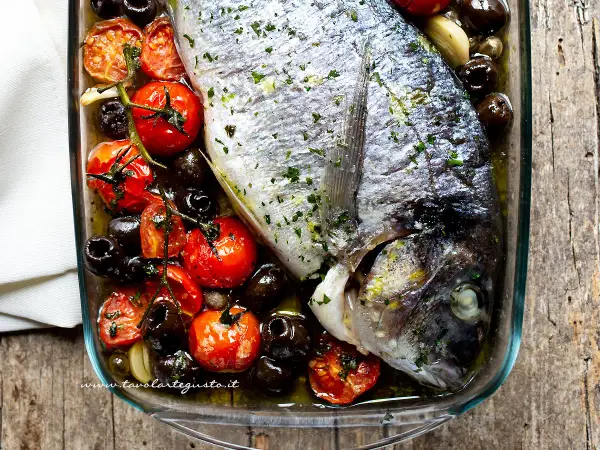 Orata al forno succulenta con pomodorini e olive nere, un piatto semplice e gustoso.