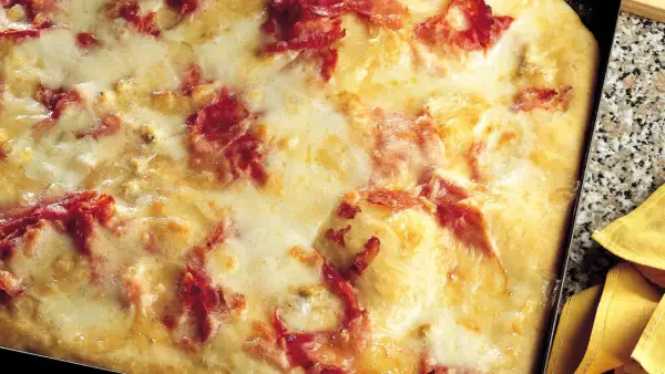 Pizza di patate filante con prosciutto croccante, un piatto invitante e gustoso.