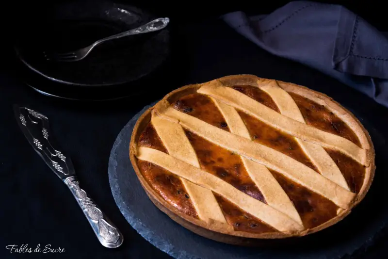 Una deliziosa crostata di ricotta, con una griglia dorata di pasta frolla, pronta per essere gustata.